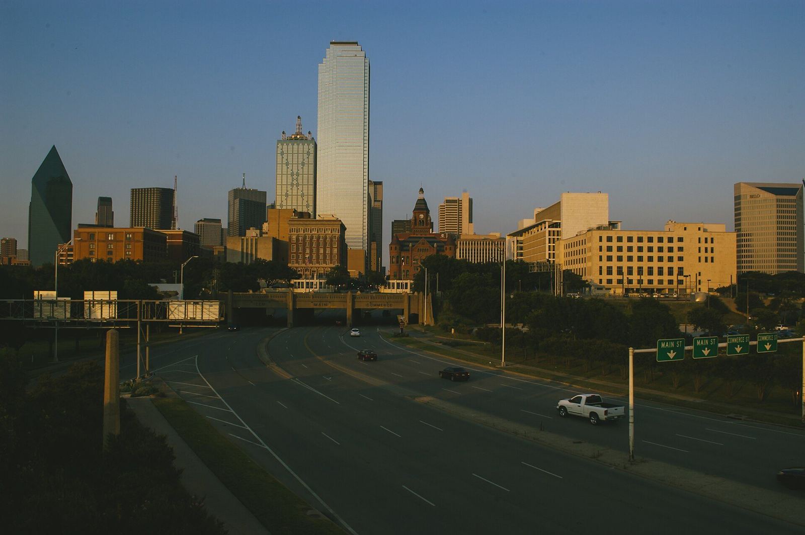 Downtown Dallas skyline at sunset seen from a freeway approach