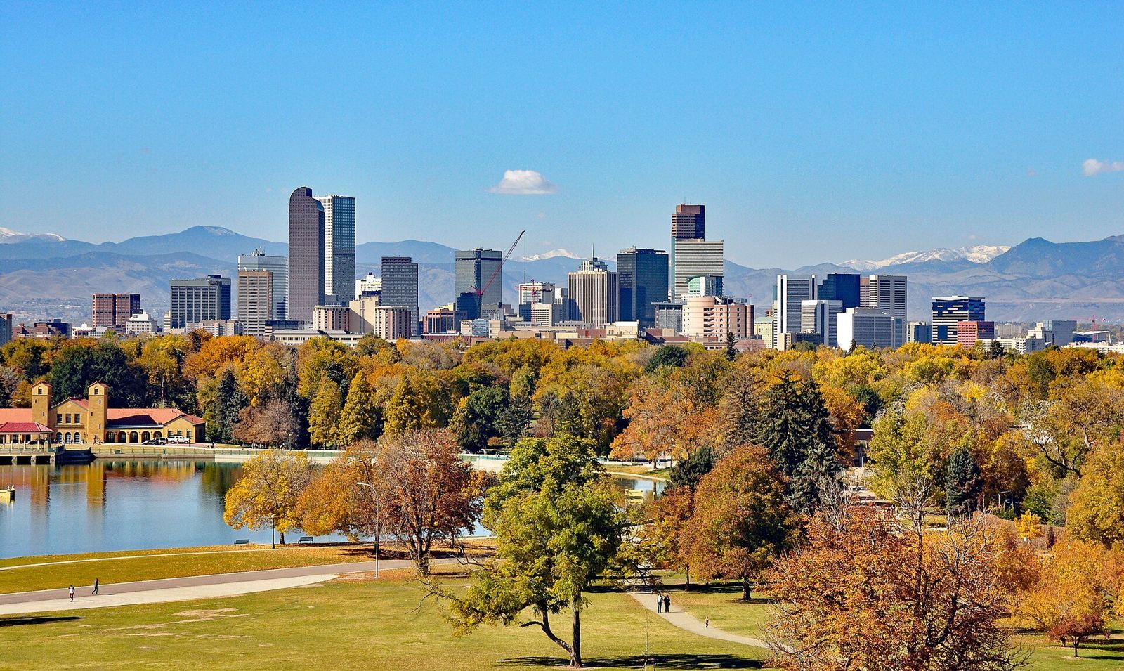 Denver skyline with the Rocky Mountains behind it seen from City Park in autumn